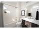 Modern bathroom with a shower-tub combo and dark-wood vanity at 3802 Newton, Denver, CO 80211