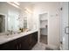 Luxurious bathroom featuring a double sink vanity, modern fixtures, and a walk in closet at 3802 Newton, Denver, CO 80211