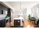 Modern kitchen with stainless steel appliances, an island with seating, and hardwood flooring at 3802 Newton, Denver, CO 80211