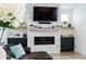 Modern living room featuring a stone fireplace, built-in shelving, and a large TV at 18360 E Ithaca Pl, Aurora, CO 80013