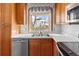 Kitchen with wood cabinets, double sink, and a view of the backyard at 6280 Zinnia St, Arvada, CO 80004