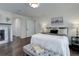 A bright bedroom featuring a fireplace, hard wood floors, and a large bed at 10609 Chadsworth Ln, Highlands Ranch, CO 80126