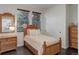 Bright bedroom with wooden bed frame, drawers and accents, plus window and closet with white sliding doors at 10609 Chadsworth Ln, Highlands Ranch, CO 80126