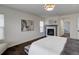 A bright bedroom featuring a fireplace, art, hard wood floors, and a large bed at 10609 Chadsworth Ln, Highlands Ranch, CO 80126