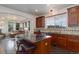 Well-lit kitchen featuring granite counters, dark wood cabinets, island with barstool seating, and a view to the living room at 10609 Chadsworth Ln, Highlands Ranch, CO 80126