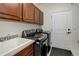Laundry room with high-efficiency washer/dryer, utility sink, ample cabinet space, and easy access to the exterior at 10609 Chadsworth Ln, Highlands Ranch, CO 80126