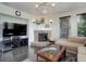Cozy living room featuring a corner fireplace, television, hardwood floors, and comfortable seating at 10609 Chadsworth Ln, Highlands Ranch, CO 80126
