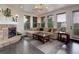 Bright living room featuring a stone fireplace, modern lighting, large windows, and a comfortable sectional sofa at 10609 Chadsworth Ln, Highlands Ranch, CO 80126