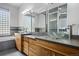 Contemporary bathroom showcasing dual glass vessel sinks, stylish cabinetry and a large block window at 4249 Oak Grove Way, Castle Rock, CO 80108