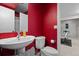Red painted bathroom with pedestal sink, toilet and exercise equipment at 4249 Oak Grove Way, Castle Rock, CO 80108