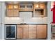 Wet bar with wood cabinets, lighting and a mini refrigerator at 4249 Oak Grove Way, Castle Rock, CO 80108