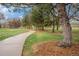 Inviting walking path through the community park, surrounded by mature trees and green space at 6613 Independence St, Arvada, CO 80004