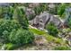 Aerial shot of the home with an expansive backyard, patio, and lush landscaping from an elevated vantage point at 9121 Sunshine Meadow Pl, Parker, CO 80134