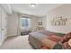 A cozy bedroom featuring a comfortable bed, window seating, and neutral decor at 9121 Sunshine Meadow Pl, Parker, CO 80134