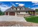 Beautiful home featuring a three-car garage, stone accents, and a well-maintained lawn at 9121 Sunshine Meadow Pl, Parker, CO 80134