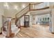 Elegant foyer with a curved staircase, hardwood floors, and views into the living spaces at 9121 Sunshine Meadow Pl, Parker, CO 80134