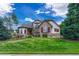Charming two-story home with beautiful stone accents, manicured lawn, and lush landscaping at 9121 Sunshine Meadow Pl, Parker, CO 80134