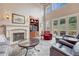 Bright living room with hardwood floors, a stone fireplace, and large windows at 9121 Sunshine Meadow Pl, Parker, CO 80134