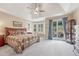 Primary bedroom features a large bed, bay windows, tray ceiling and sliding glass door to the backyard at 9121 Sunshine Meadow Pl, Parker, CO 80134