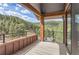 Covered balcony boasts wood flooring, wooden structural beams and treed views at 795 Pine Brook Rd, Boulder, CO 80304