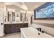Bright bathroom features a soaking tub with modern fixtures and views of a snowy landscape at 795 Pine Brook Rd, Boulder, CO 80304