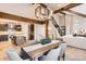 Open dining area with wood beams, a modern chandelier, staircase, and views into the kitchen at 795 Pine Brook Rd, Boulder, CO 80304
