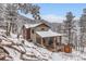 Beautiful mountain home with a covered porch and snowy landscaping creates a peaceful winter setting at 795 Pine Brook Rd, Boulder, CO 80304