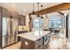 Open kitchen featuring a large island with seating, stainless steel appliances, and a connected dining area at 795 Pine Brook Rd, Boulder, CO 80304