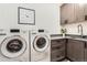 Laundry room features modern washer and dryer, with gray countertops and cabinets at 795 Pine Brook Rd, Boulder, CO 80304