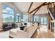 Bright and airy living room with high ceilings, wood beams, ample seating, and large view windows at 795 Pine Brook Rd, Boulder, CO 80304