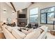 Cozy living room with a sleek fireplace, high ceilings, and large windows offering beautiful views at 795 Pine Brook Rd, Boulder, CO 80304