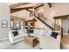 Open-concept living room with high ceilings, wood beams, fireplace, and a staircase leading to the upper level at 795 Pine Brook Rd, Boulder, CO 80304