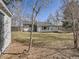 Serene backyard with mature trees, grass and a gray house, creating a peaceful and private setting at 35 Everett St, Lakewood, CO 80226