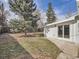 Backyard with lush greenery, mature trees, and sliding doors, offering a tranquil outdoor space at 35 Everett St, Lakewood, CO 80226