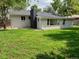 Spacious backyard with a well-maintained lawn and a home featuring a prominent brick chimney at 35 Everett St, Lakewood, CO 80226
