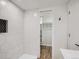 Bathroom features a sleek design with modern fixtures, white tiling, and an open closet at 35 Everett St, Lakewood, CO 80226
