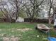 Large backyard with mature trees, a white shed, and a trailer in the grassy area at 1985 Blackhawk St, Aurora, CO 80011