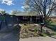 View of the front yard featuring an overgrown garden, containers, and a large dumpster at 1985 Blackhawk St, Aurora, CO 80011