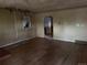 Spacious living room featuring hardwood floors, dated decor, and a doorway at 1985 Blackhawk St, Aurora, CO 80011