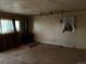 Interior shot of the living room with hardwood floors, dated decor, and unique track lighting at 1985 Blackhawk St, Aurora, CO 80011