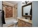 Cozy bathroom with granite countertop vanity, tile backsplash, and bathtub with shower at 10127 Bluffmont Ln, Lone Tree, CO 80124