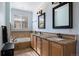 Bright bathroom with double sink vanity, framed mirrors, tile flooring, and soaking tub at 10127 Bluffmont Ln, Lone Tree, CO 80124