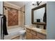 Well-lit bathroom featuring granite countertops, a decorative mirror, bathtub, and a stylish vanity area at 10127 Bluffmont Ln, Lone Tree, CO 80124