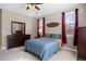 Bright bedroom with a large mirror, dresser, ceiling fan, and curtains framing the windows at 10127 Bluffmont Ln, Lone Tree, CO 80124