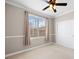 Bright, empty bedroom with chair rail, neutral carpeting, ceiling fan, and large window with blinds at 10127 Bluffmont Ln, Lone Tree, CO 80124