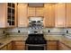 Charming kitchen with granite counters, wooden cabinets, stainless steel stove and decorative tile backsplash at 10127 Bluffmont Ln, Lone Tree, CO 80124