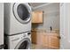 Convenient laundry room featuring a stacked washer and dryer with wood cabinets and granite countertops at 10127 Bluffmont Ln, Lone Tree, CO 80124