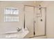 A bathroom with a glass-enclosed shower, soaking tub, and ample natural light through decorative windows at 20000 Mitchell Pl # 51, Denver, CO 80249