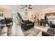 Open-concept living room with modern furniture, wood-look floors, open staircase, and kitchen view at 20000 Mitchell Pl # 51, Denver, CO 80249