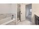 Bathroom featuring tub, shower, and marble floors with modern fixtures at 6926 Kendrick Ln, Arvada, CO 80007